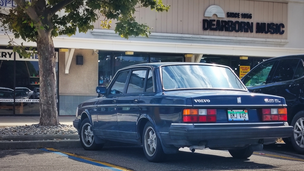 Blue Volvo 240 DL outside Dearborn Music.