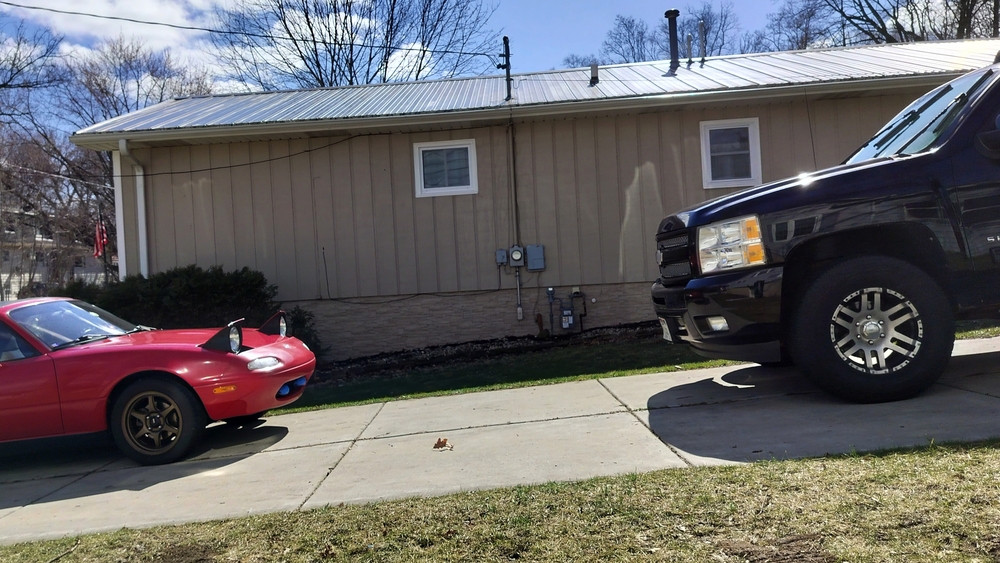 Mazda Miata and Chevrolet Silverado in a staredown in my driveway.