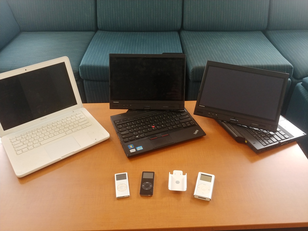 Used MacBook, two ThinkPad X230 Tablets, two iPod nanos and an iPod Mini on a table.