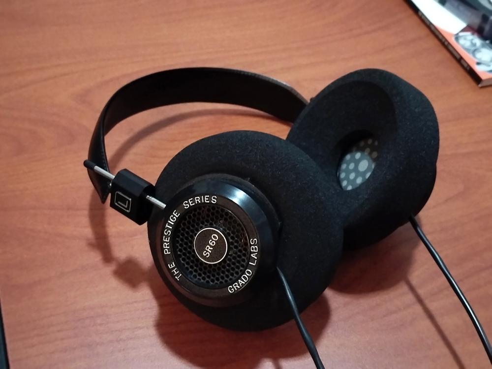 Grado Labs Prestige Series SR60i headphones with aftermarket G cushions laying on wood table.